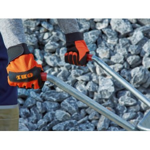 Mani con guanti da lavoro OBI (taglia 10) che tengono una carriola davanti a delle pietre.