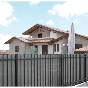 Frangivista grigio t.b.t. su una recinzione davanti a una casa.