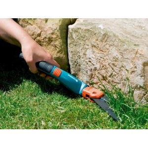 Cesoie per erba Gardena Comfort tagliano i bordi del prato vicino a una pietra.