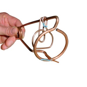 Primo piano di una mano che tiene due trappole per topi campagnoli in filo di rame.