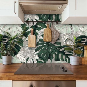 Paraschizzi t.b.t. con motivo a foglie di monstera in cucina.