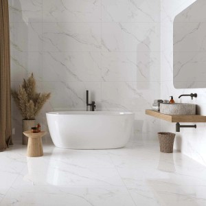 Bagno luminoso con piastrelle per pavimenti e rivestimenti bianchi effetto marmo.