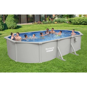 Piscina fuori terra ovale con pareti in acciaio e divertimento balneare per tutta la famiglia in giardino.