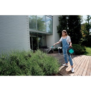 Donna che innaffia il giardino con avvolgitubo. Avvolgitubo categoria Carrelli-avvolgitubo.