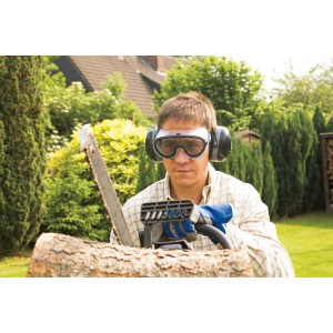 Uomo che indossa occhiali di protezione LUX con rete metallica mentre sega legna in giardino.