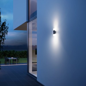 Moderna lampada da parete per esterni a LED Steinel L 910 S antracite con sensore di movimento su parete di casa.