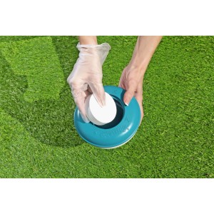 Galleggiante dosatore Bestway grande, turchese-bianco. Una mano inserisce una pastiglia di cloro per piscina.