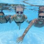 Gruppo nuota sott'acqua in piscina con maschere da immersione. Maschere, occhialini e accessori da immersione