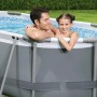 Piscina fuori terra: Padre e figlia nella piscina grigia in giardino.
