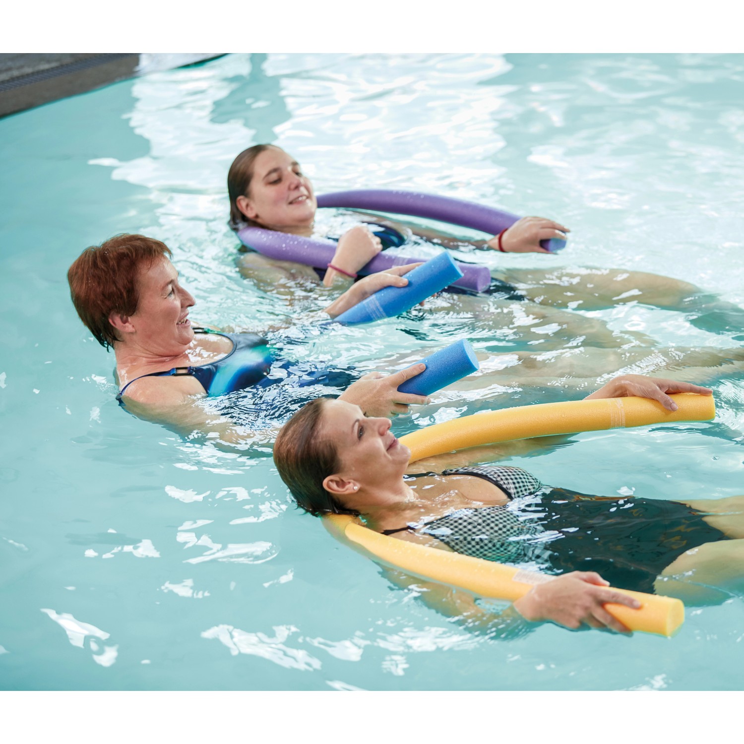 Persone che si rilassano in acqua con colorate Comfy swim noodles.