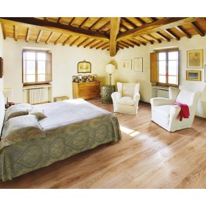 Pavimento in parquet t.b.t. chiaro in una camera da letto con soffitto con travi in legno.