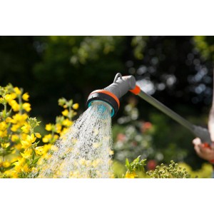 Lancia per irrigazione Gardena Comfort 90 cm mentre annaffia fiori gialli in giardino.