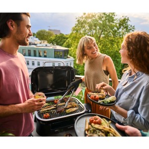 Scena con barbecue elettrico t.b.t. utilizzato con amici sul balcone.