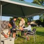 Coleman FastPitch OnePush Shelter L: Tenda da campeggio verde e bianca con famiglia che fa un picnic.