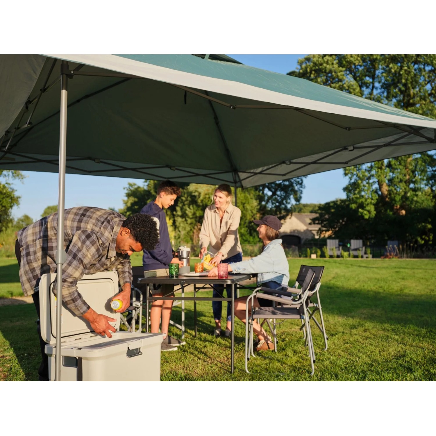 Coleman FastPitch OnePush Shelter L: Tenda da campeggio verde e bianca con famiglia che fa un picnic.