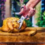 Forbici da carne Char-Broil in uso: tagliare pollo arrosto su tagliere di legno. Utensile per grill.