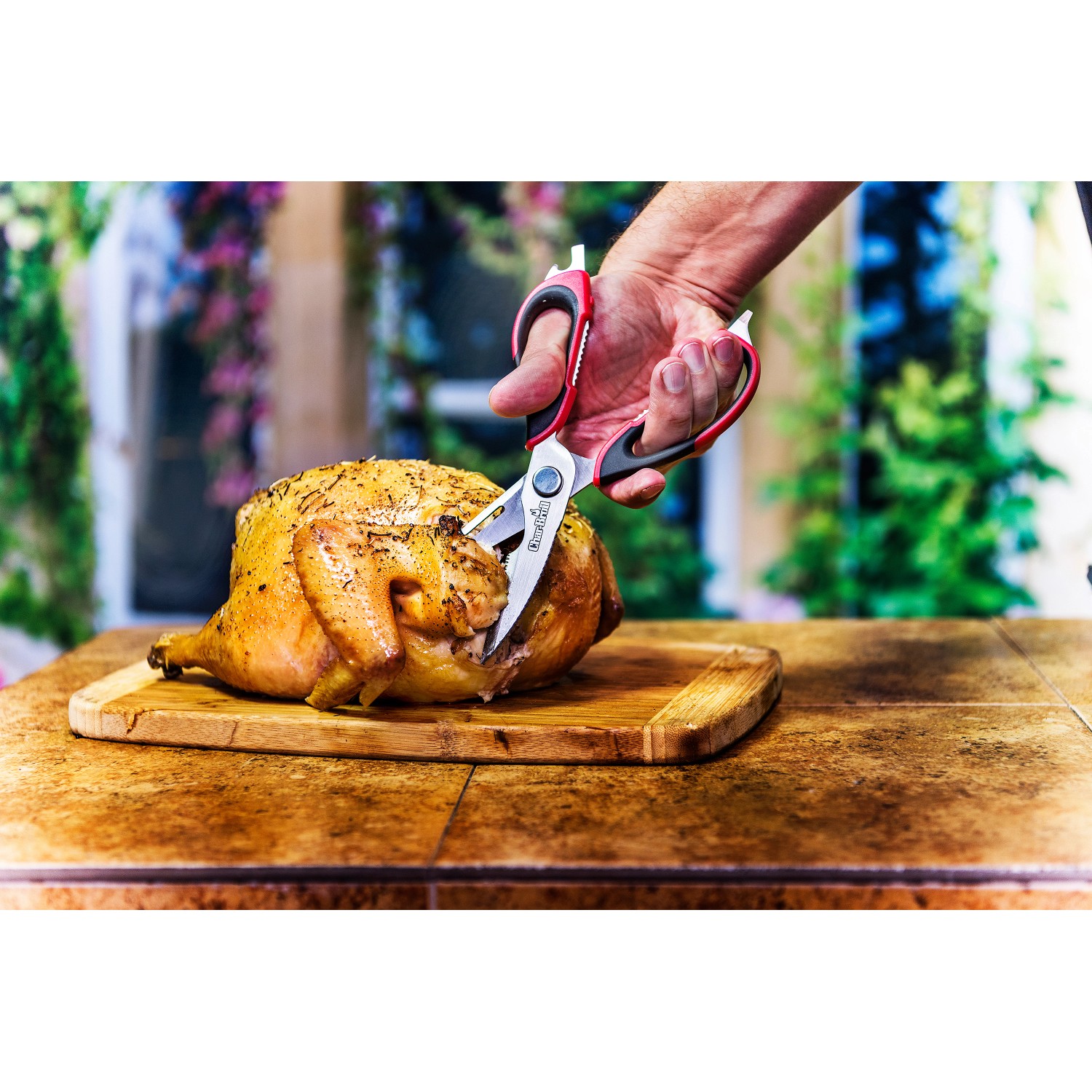 Forbici da carne Char-Broil in uso: tagliare pollo arrosto su tagliere di legno. Utensile per grill.