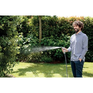 Uomo che irriga il giardino con lancia per irrigazione t.b.t.. Ideale per l'irrigazione del giardino.