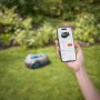 Robot tagliaerba in giardino, controllato tramite app per smartphone.