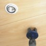 Set di seghe a tazza in uso: Foratura di un foro in un soffitto di legno con lampada.