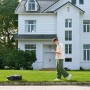Uomo che utilizza il robot tagliaerba t.b.t. con smartphone in giardino.