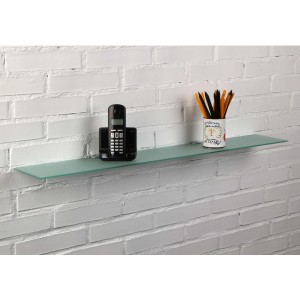Mensola a muro in vetro t.b.t. montata su parete di mattoni bianchi con telefono e portapenne.