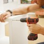 Avvitatore a batteria Black+Decker BDCDD12K avvita un mobile bianco.