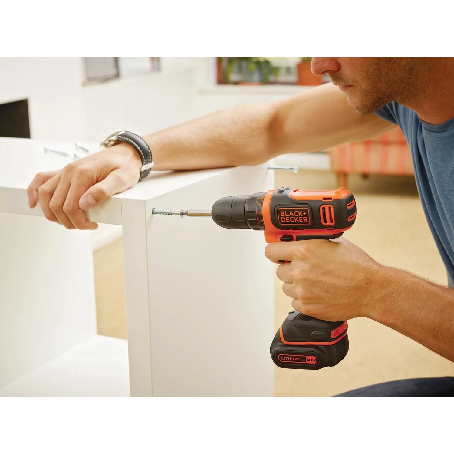 Avvitatore a batteria Black+Decker BDCDD12K avvita un mobile bianco.