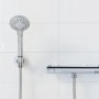 Set doccia Wenko Basic Line, 2 pezzi, soffione cromato con tubo flessibile su parete bianca.