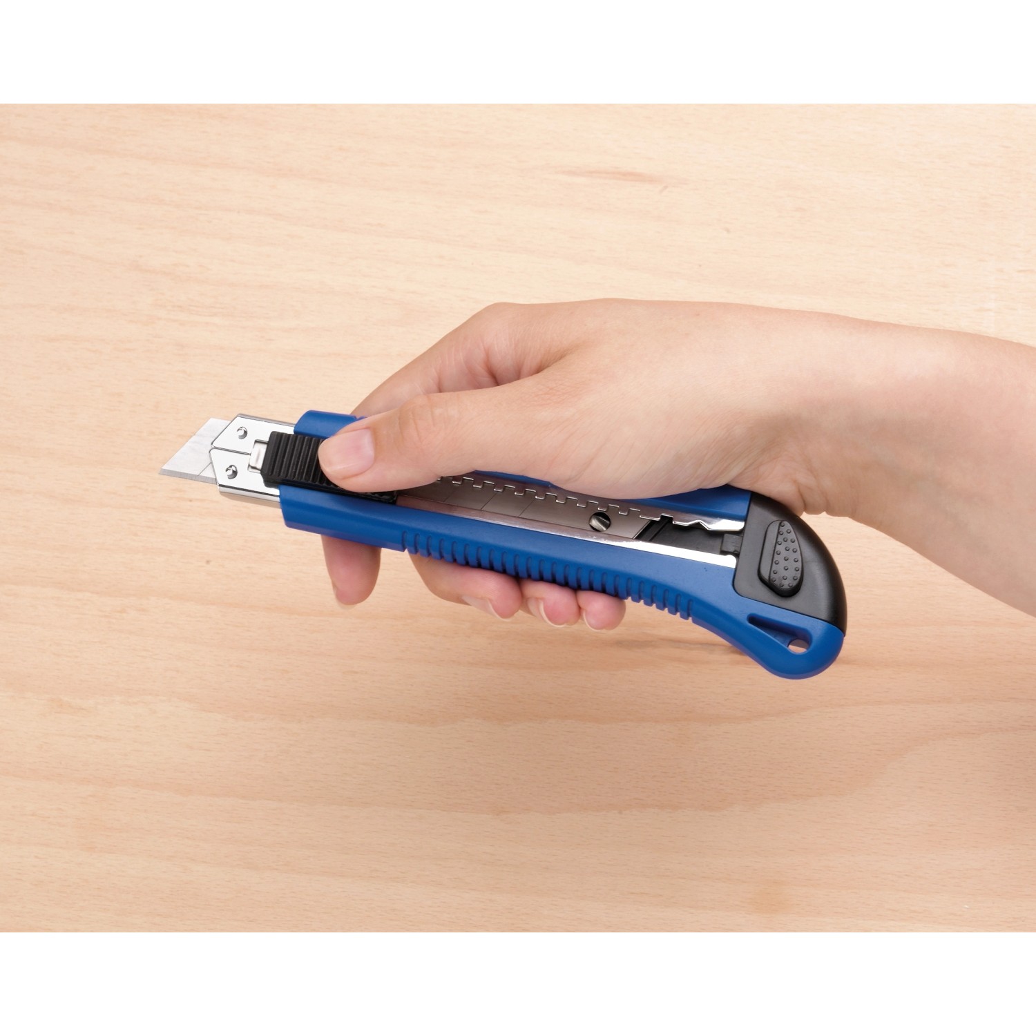 Mano che tiene un cutter LUX Classic 100 mm blu. Coltello con corpo in metallo e blocco lama.