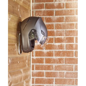 Casco da moto su supporto a parete. Casco grigio con visiera, montato a parete.