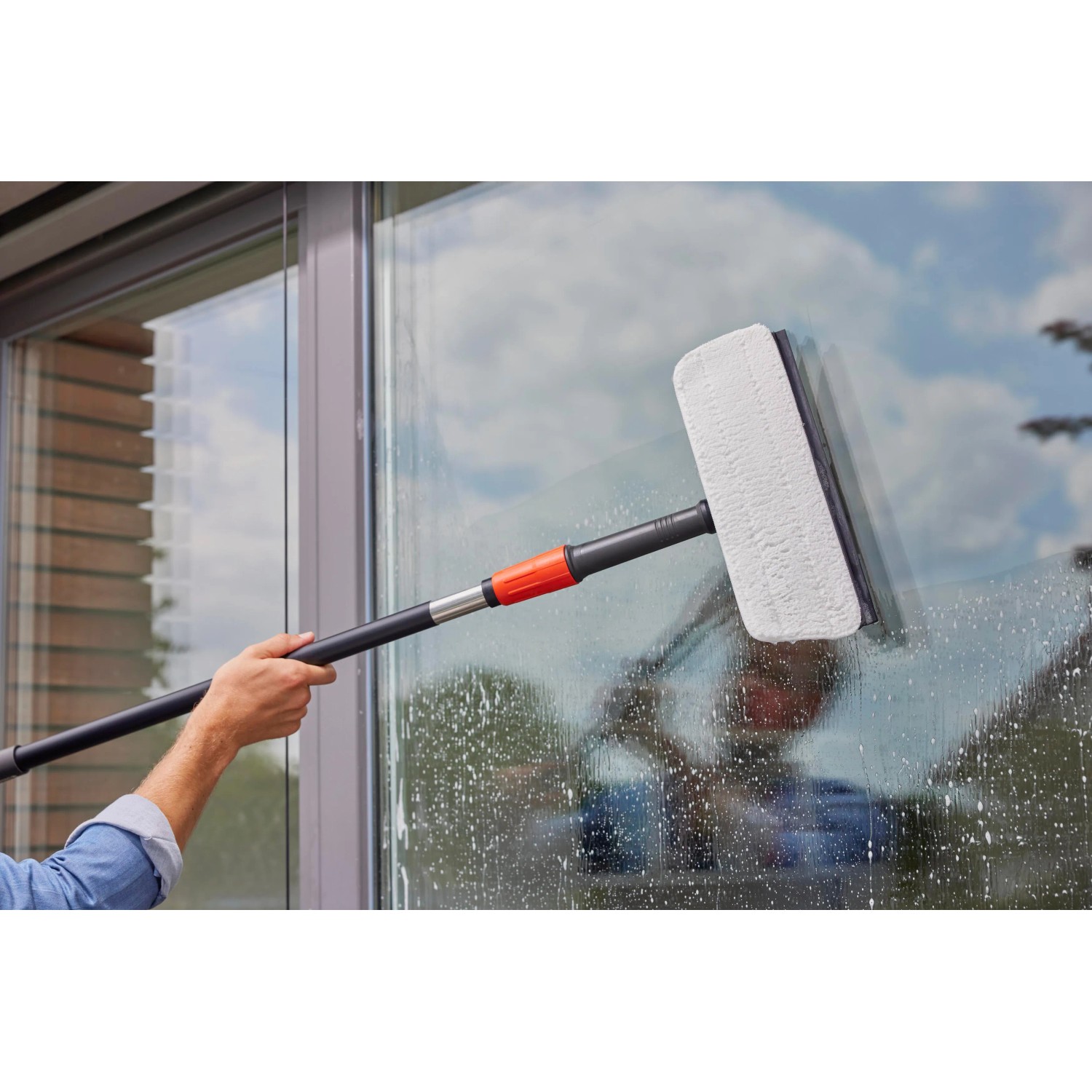 Gardena Cleansystem lavavetri con manico e panno in microfibra in uso per la pulizia dei vetri.