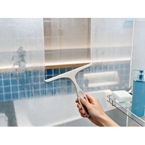 Mano usa tergivetro doccia OBI per rimuovere acqua da vetro appannato. Per doccia senza aloni e protezione calcare.