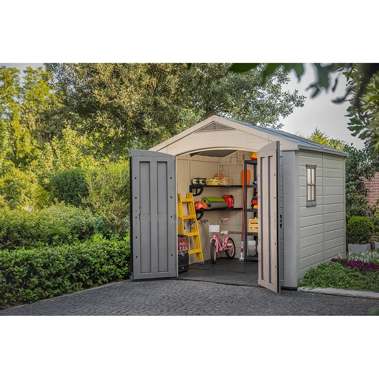 Casetta da giardino in plastica Keter 6,32 m² aperta, color grigio-beige, con scaffali e attrezzi da giardino.