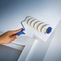Rullo per pittura LUX 25cm mentre dipinge una parete, Polymix, oro-grigio a righe.