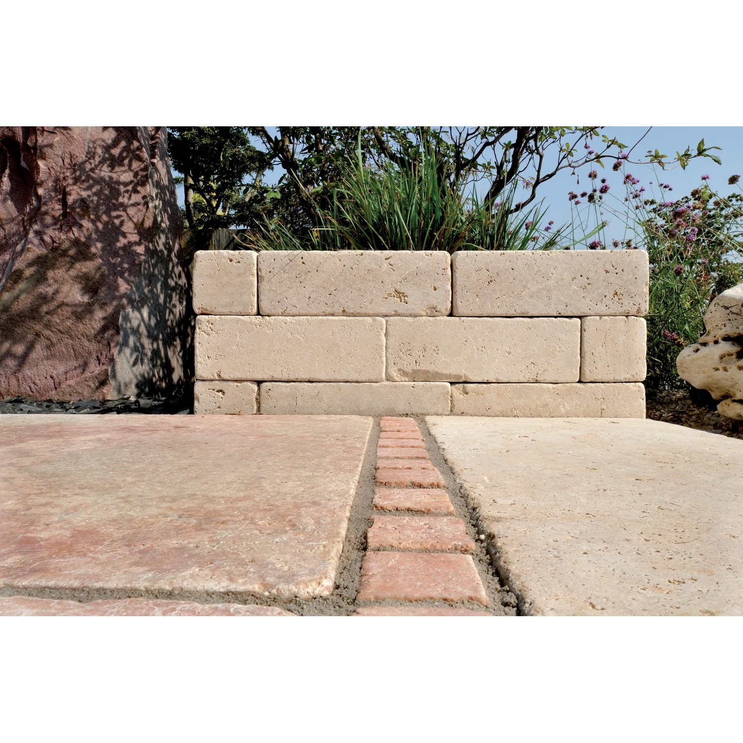 Muro fatto di pietre di bordo/cordoli t.b.t. chiare in giardino.
