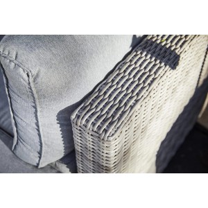 Dettaglio: poltrona lounge Olea in polyrattan color sabbia con cuscini grigio chiaro.