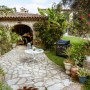 Barbecue a gas t.b.t. in giardino con tavolo e piante.