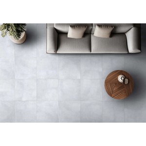 Piastrelle chiare t.b.t. in soggiorno con divano e tavolo, vista dall'alto.