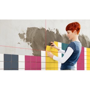 Donna che piastrella con laser a croce Bosch Quigo III per un allineamento preciso.