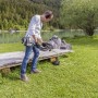Uomo che lavora in giardino con il decespugliatore a benzina Al-Ko BC 223 L-S vicino al lago.