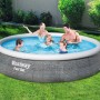 Famiglia nella piscina Bestway Fast Set in giardino. Divertimento nella piscina fuori terra rotonda.