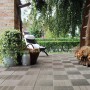 Pavimenti autobloccanti t.b.t. posati su una terrazza con mobili da giardino sullo sfondo.