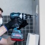 Un utente fora un foro in una parete con una punta per piastrelle Bosch Expert Hard Ceramic.