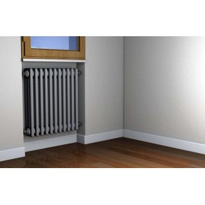 Radiatore grigio in un angolo di stanza con pavimento in legno e finestra.