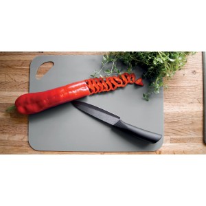 Tagliere t.b.t. grigio con peperone, erbe e coltello.