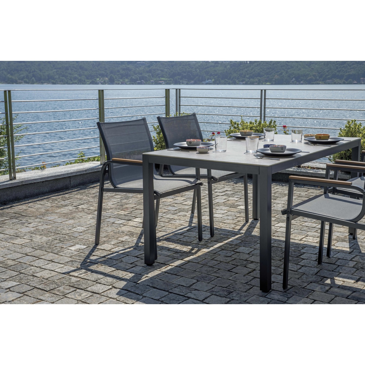 Set di mobili da giardino t.b.t. grigio con tavolo e sedie su terrazza con vista lago.