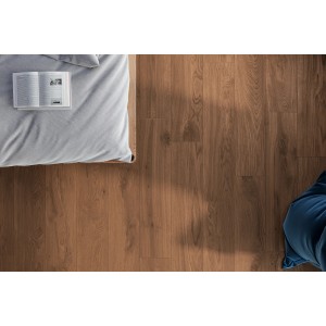 Piastrelle per pavimenti marroni effetto legno posate. Camera da letto con letto e libro.