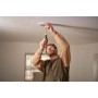 Un uomo sta avvitando qualcosa al soffitto con un cacciavite.