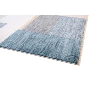 Tappeto moderno con motivo geometrico nei toni del blu, grigio e beige.